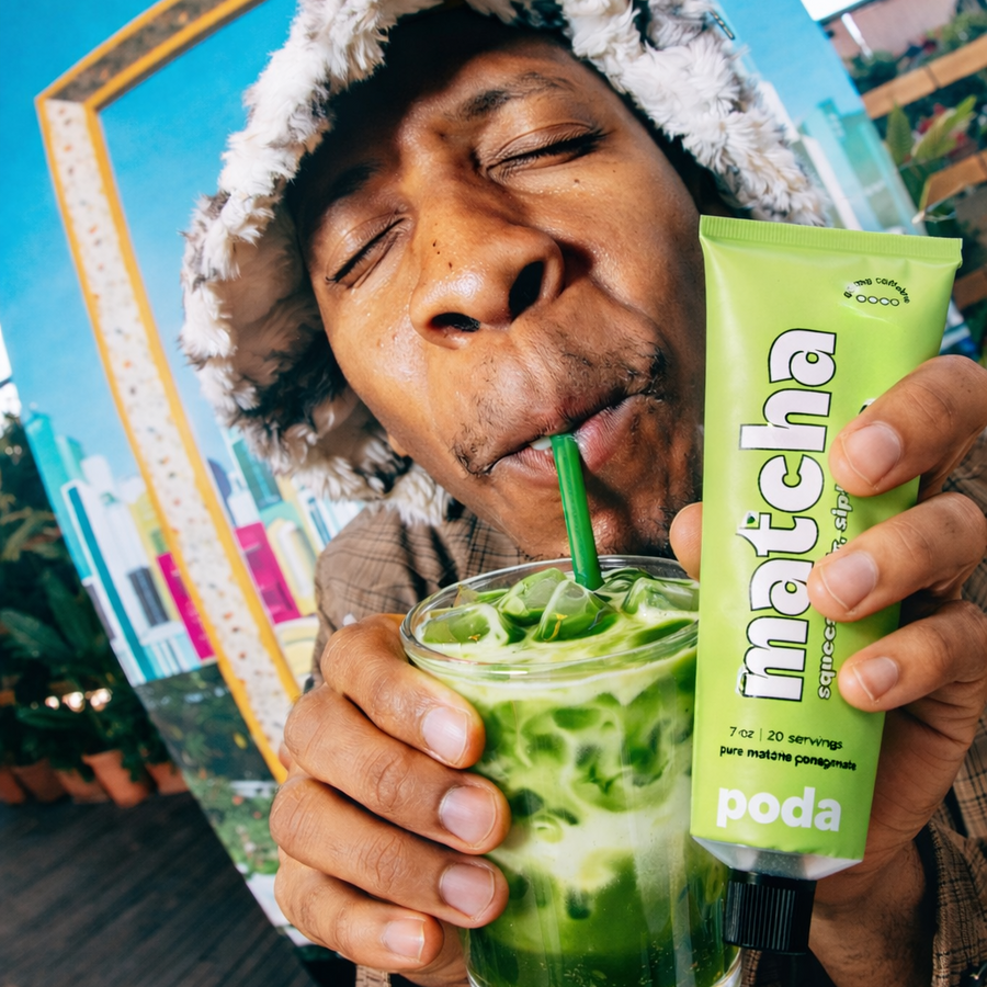 Customer drinking an iced Poda matcha latte while holding the tube