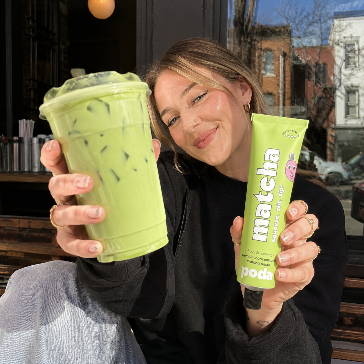 Customer holding a Poda matcha latte and matcha paste tube