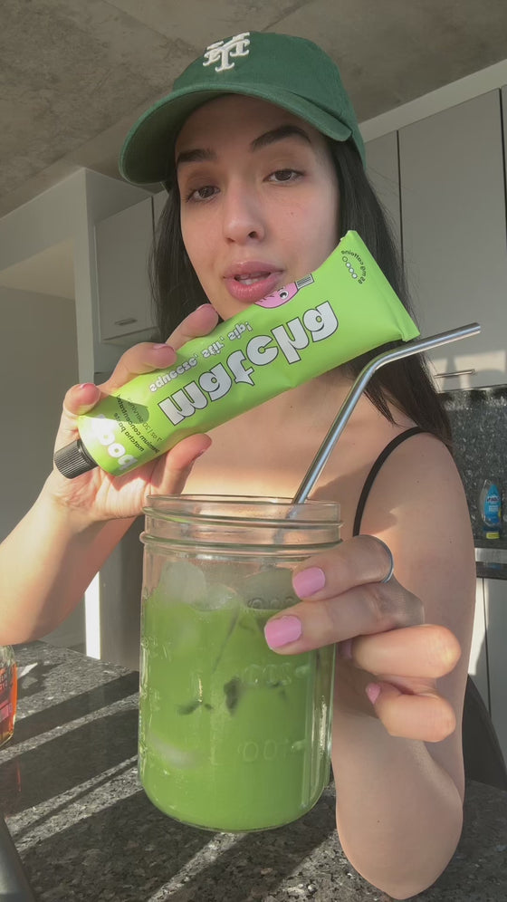 Customer holding Poda matcha paste beside an iced matcha latte