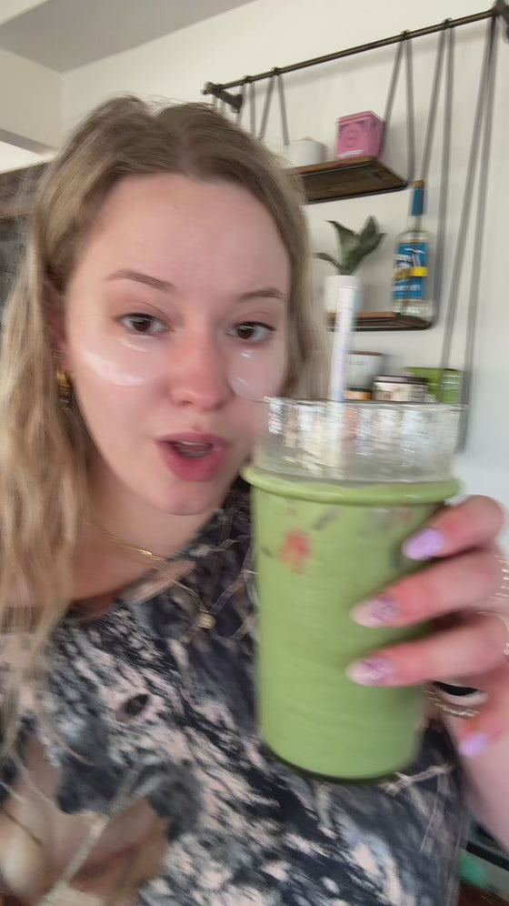 Customer holding an iced Poda matcha latte at home